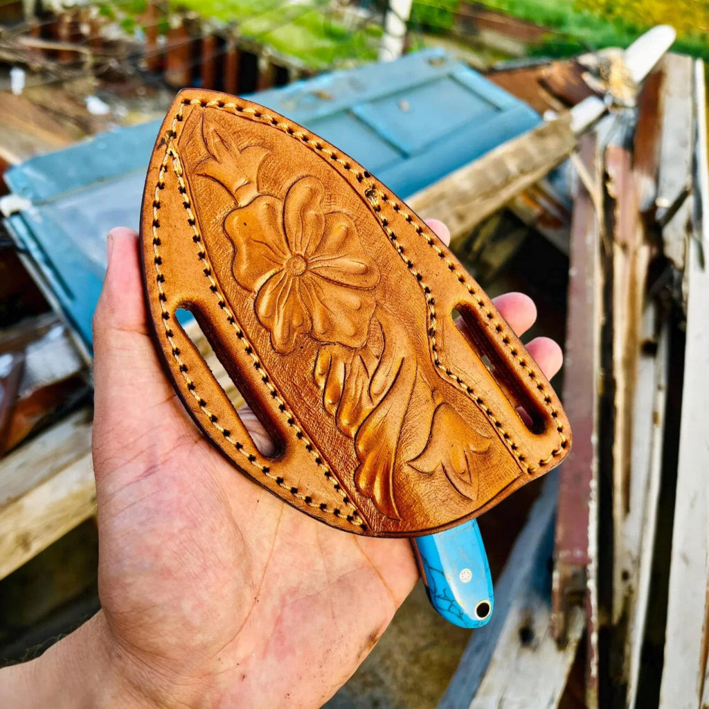 Simple cowboy hunting knife with Damascus steel blade and marble handle, shown with pancake sheath. Crafted by MALIKA KNIVES.