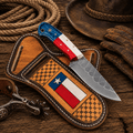 Handmade cowboy knife with steel blade, flag handle, and leather belt sheath by SHAM KNIVES.
