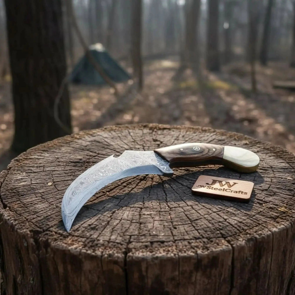 Damascus JW SteelCrafts karambit knife with textured blade and ergonomic handle, designed for precision and safety.