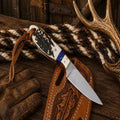 Elk Ridge Buckaroo cowboy knife by SHAM KNIVES with D2 steel blade and floral pancake sheath, designed for hunting and outdoor use.