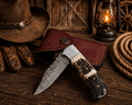 Handcrafted Damascus pocket knife with engraved details, stag horn and Pakka wood handle, ideal for EDC and hunting.