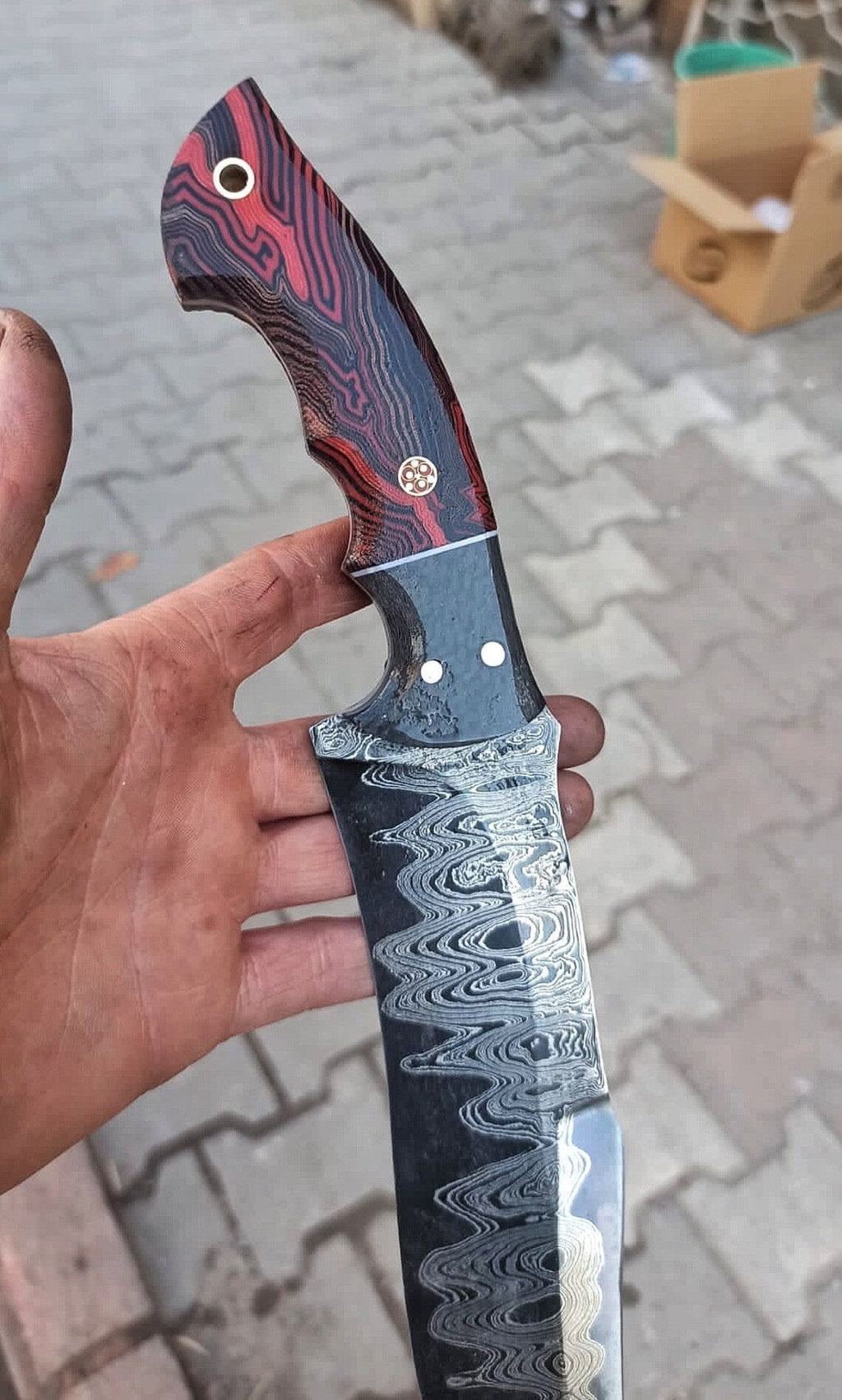 Handcrafted Damascus steel hunting knife with resin handle and leather sheath, featuring a 10-inch blade from Knives Gear Garage.