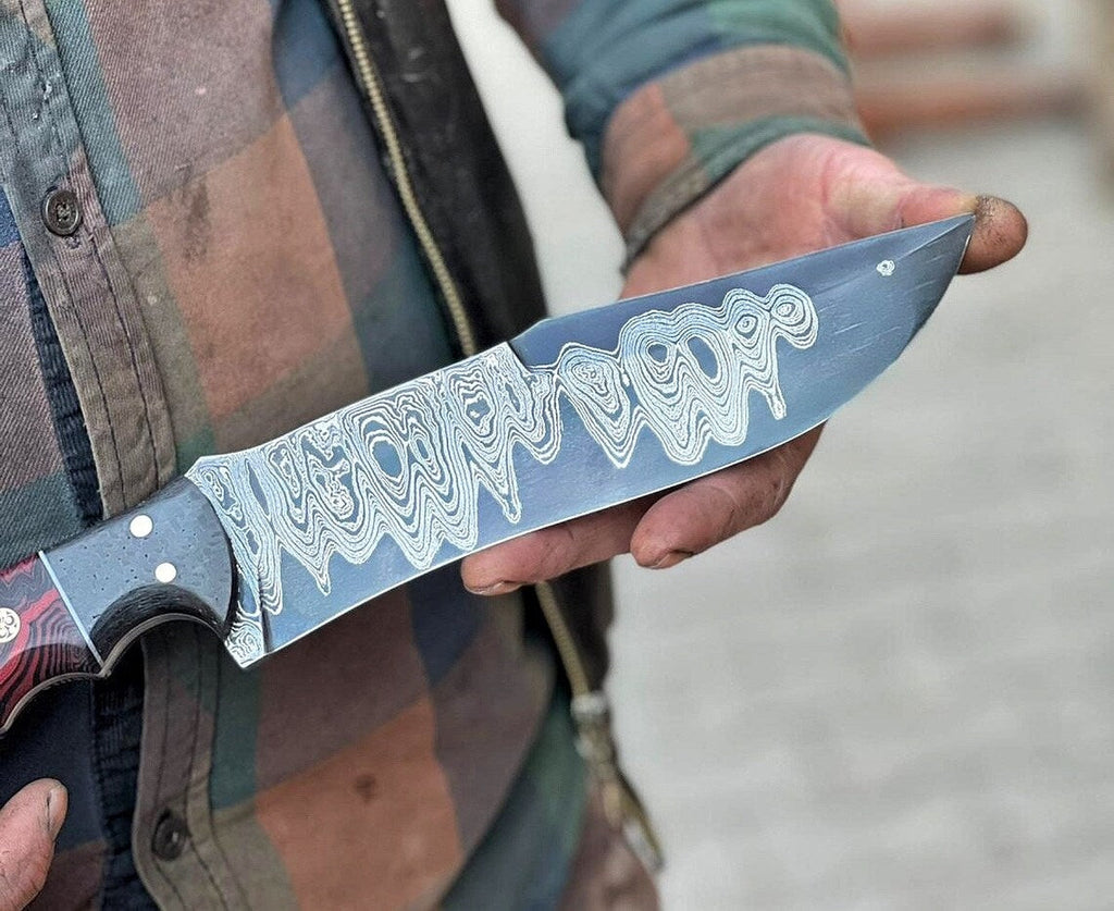 Handmade Damascus steel hunting knife with resin handle and leather sheath, crafted by Knives Gear Garage.