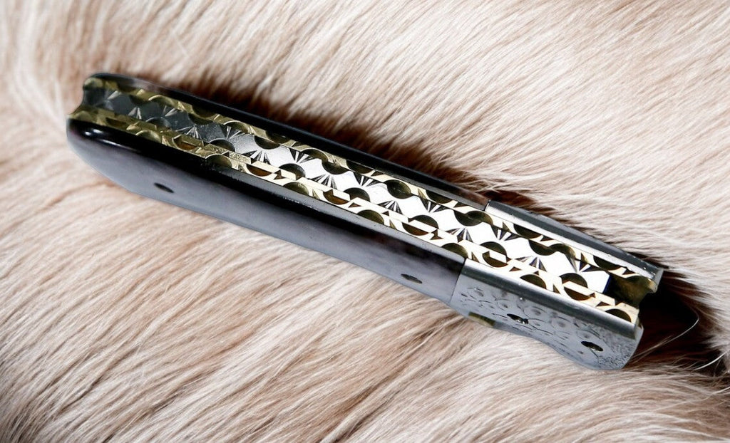 Custom handmade Damascus pocket knife with a colorful bone handle, showcasing intricate blade pattern and detailed craftsmanship.