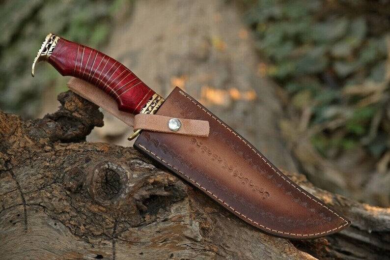 Custom handmade Damascus steel hunting Bowie knife with brass guard, pakkawood handle, and leather sheath from Knives Gear Garage.