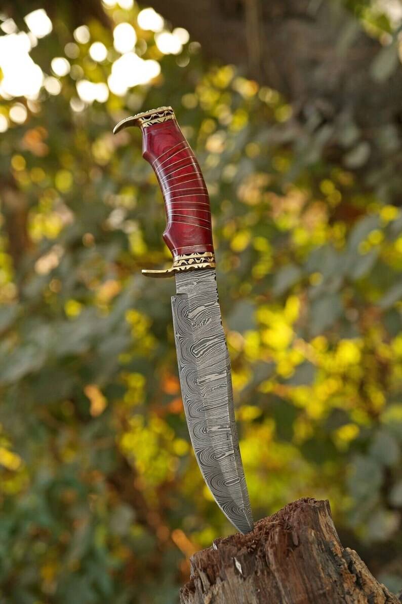 Custom handmade Damascus steel hunting Bowie knife with brass guard and pakkawood handle, includes leather sheath.