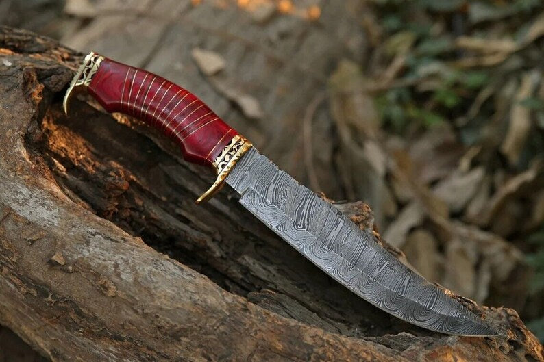 Custom handmade Damascus steel hunting Bowie knife with brass guard and pakkawood handle, shown with leather sheath.