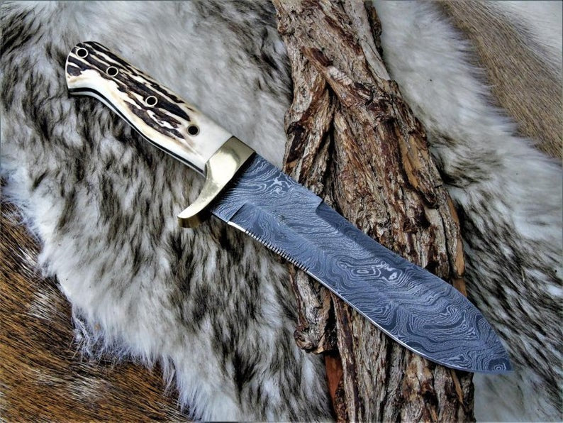 Handmade Damascus steel stag horn hunting knife with leather sheath from Knives Gear Garage, showing the detailed blade and handle.