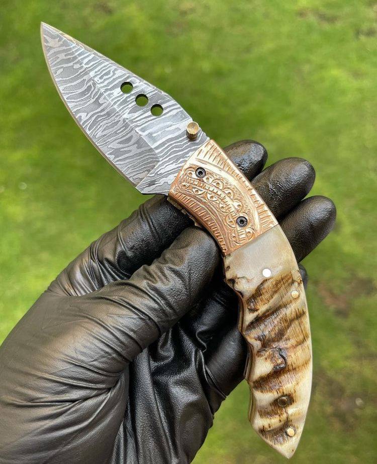 Damascus folding pocket knife by cskforged with a sleek blade, foldable design, and textured handle for everyday carry.
