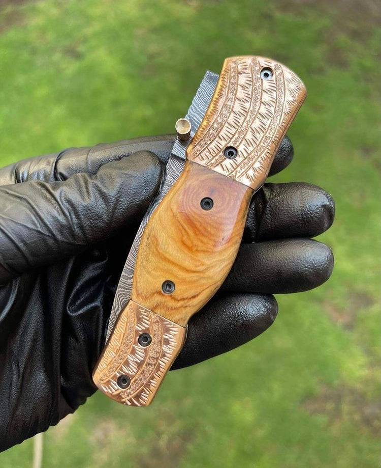 Damascus Blade EDC folding pocket knife by cskforged with a textured handle and a partially open blade on a white background.