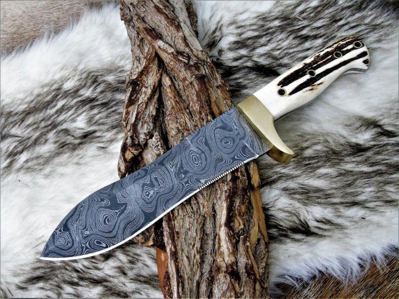 Handmade Damascus steel stag horn hunting knife with leather sheath, featuring detailed craftsmanship from Knives Gear Garage.