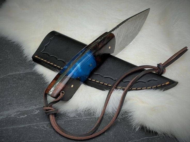 Handmade Damascus steel full tang knife by Knives Gear Garage with a textured blade and ergonomic handle.