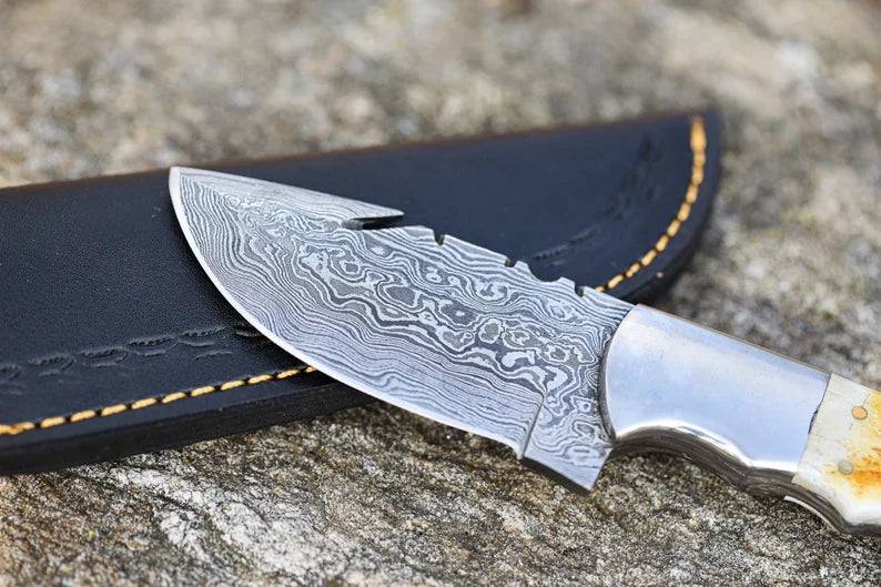 Handmade Damascus steel hunting skinner knife with textured handle and sharp blade, crafted for precise game skinning by Knives Gear Garage.
