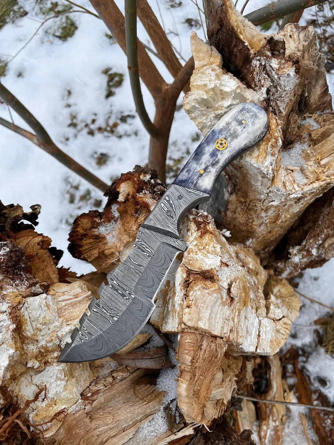 Custom handmade Damascus steel tracker knife with textured handle and sharp blade, crafted by Knives Gear Garage.