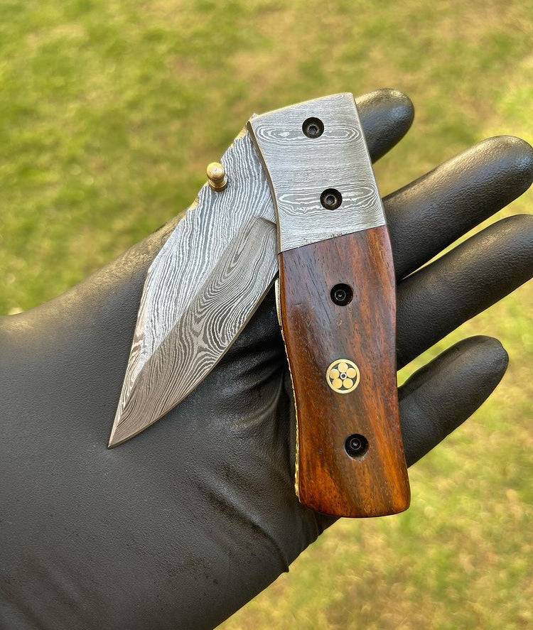 Damascus folding pocket knife by cskforged with a sleek Damascus steel blade and ergonomic handle, displayed open.