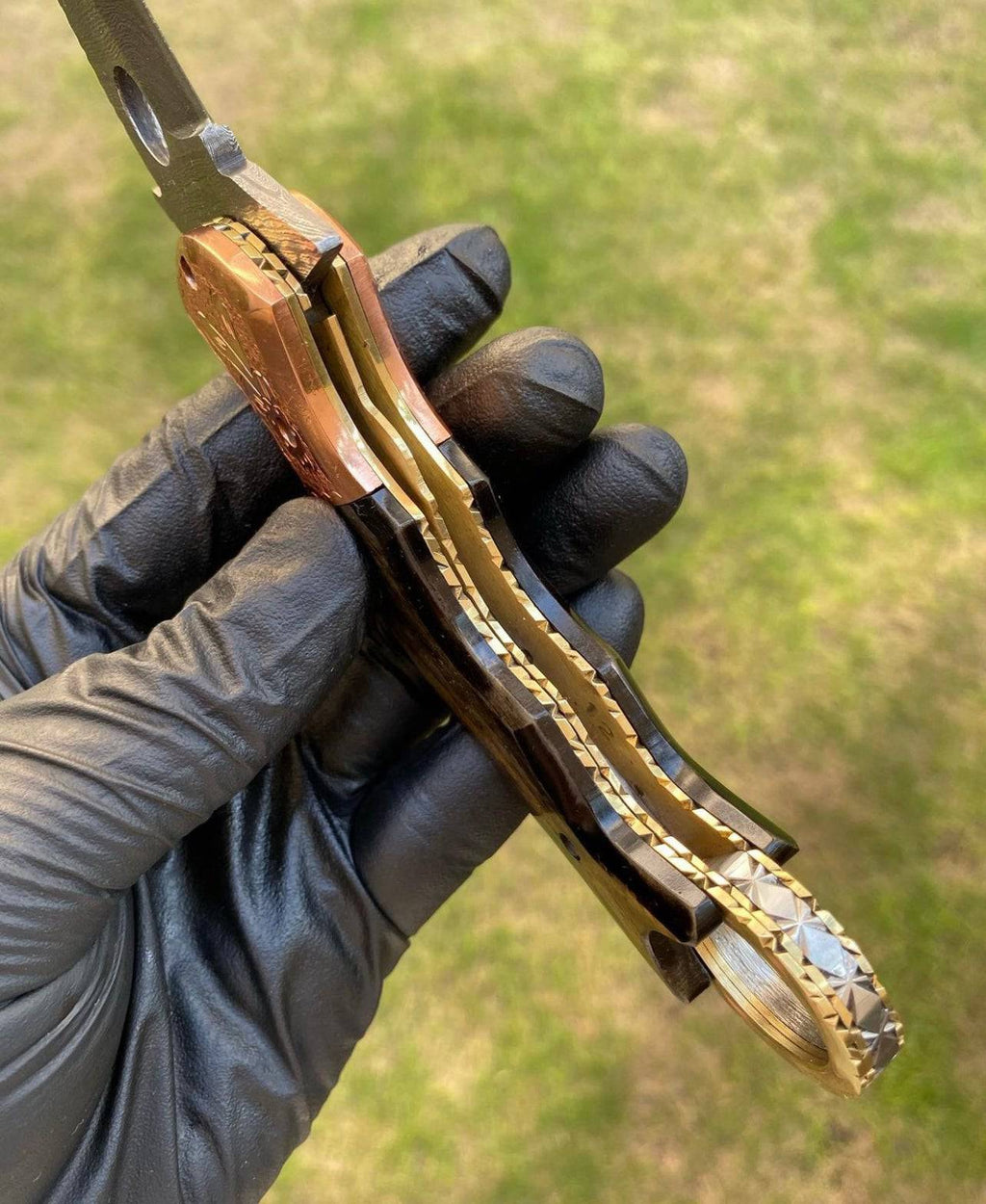 Damascus folding pocket knife with karambit design by cskforged, showcasing intricate patterned blade and ergonomic handle.