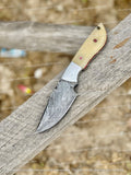 Handmade Damascus steel skinning knife with 8-inch blade, camel bone handle, and leather sheath by Knives Gear Garage.