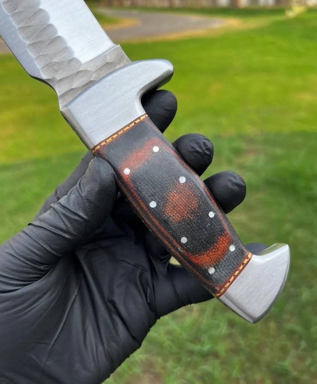 Fixed blade camping knife by cskforged with a hand-forged D2 steel blade and leather sheath on a wooden surface.