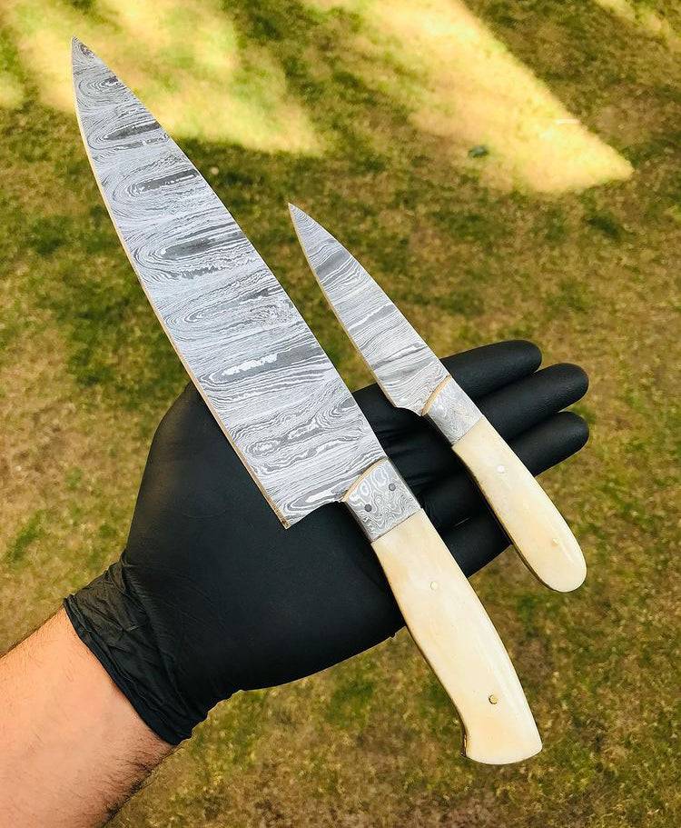 Custom handmade Damascus steel chef knives set by cskforged, featuring two high-quality, intricately patterned blades on a wooden surface.