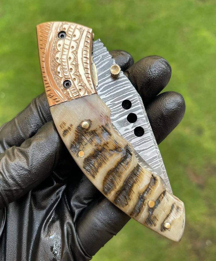 Damascus folding pocket knife by cskforged with a sleek, foldable blade and textured handle for EDC use.