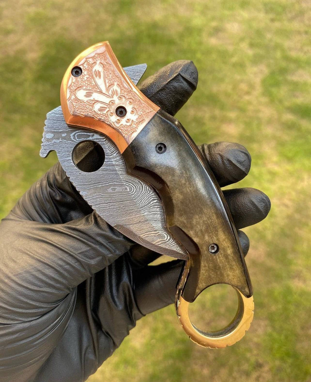 Damascus folding pocket knife with karambit design by cskforged, featuring intricate patterns and a compact, foldable blade.