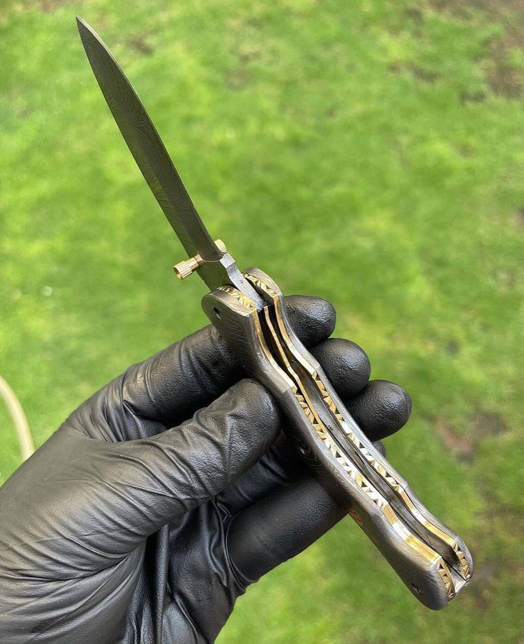 Damascus folding pocket knife with a full blade, featuring a textured handle and sleek folding mechanism by cskforged.