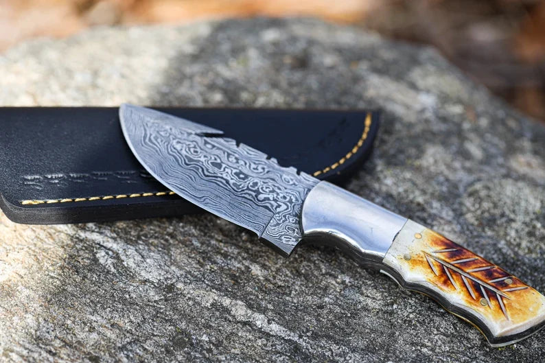 Handmade Damascus steel hunting skinner knife with a textured handle and sharp blade, ideal for game processing by Knives Gear Garage.