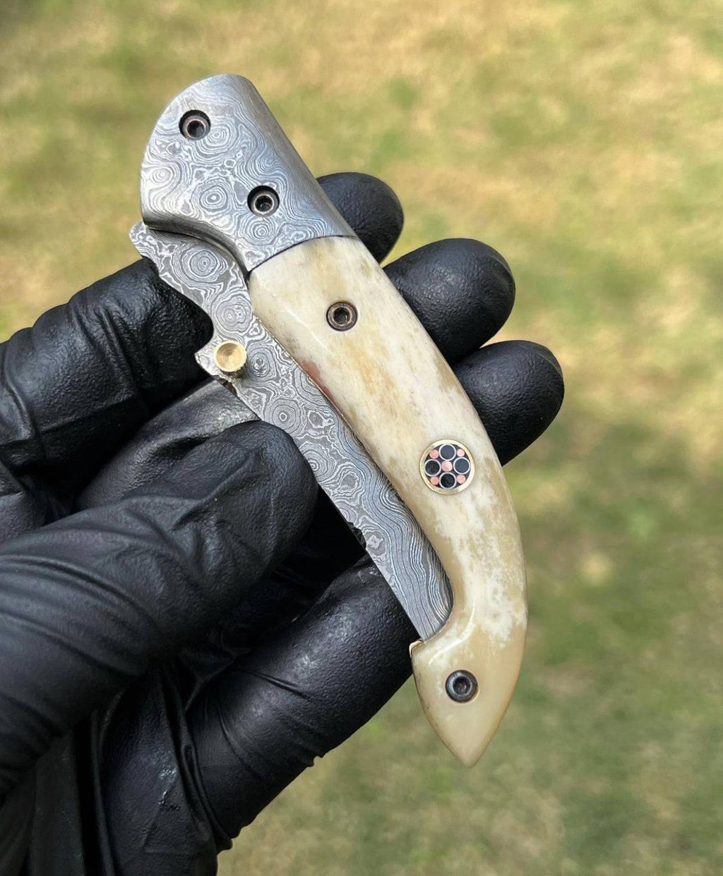 Damascus Blade EDC folding pocket knife by cskforged with a patterned Damascus steel handle and a sleek folding blade.