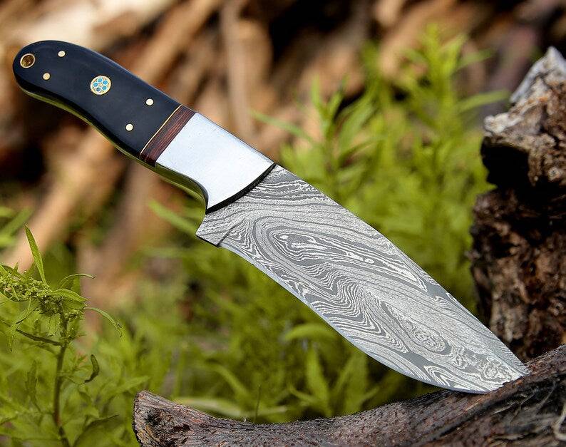 Custom handmade Damascus hunting knife with rosewood and buffalo horn handle, steel bolster, 9-inch blade, leather sheath.