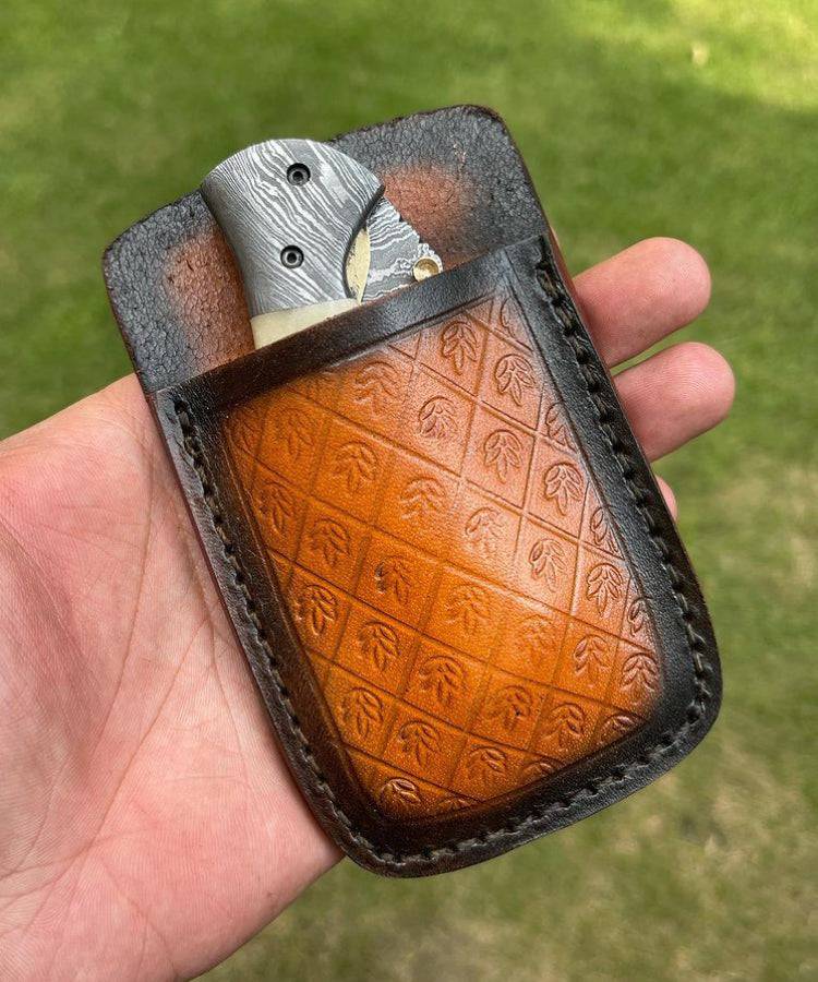 Damascus folding pocket knife by cskforged with a textured blade and ergonomic handle, ideal for everyday carry and outdoor use.