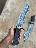 Custom handmade Damascus steel hunting Bowie knife with a leather sheath, featuring intricate patterning and a sturdy handle.