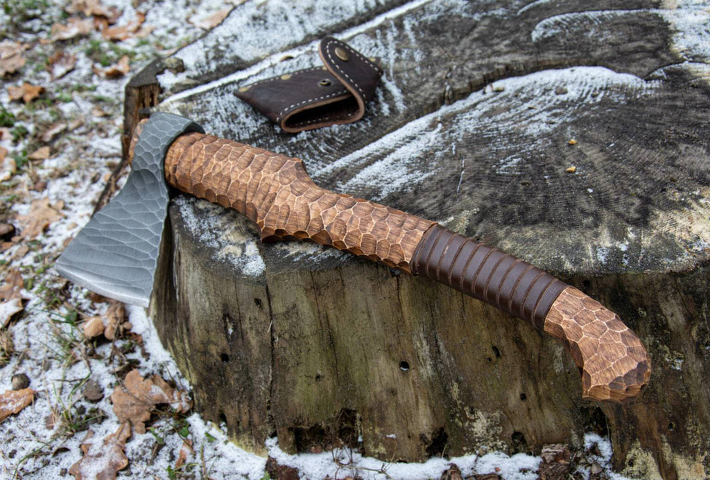 Hand-forged axe from Knives Gear Garage with a wooden handle and metal blade, ideal for camping or outdoor chopping tasks.