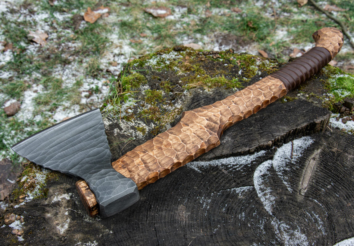 Hand-forged axe from Knives Gear Garage with wooden handle and sharp metal blade, ideal for chopping and outdoor use.