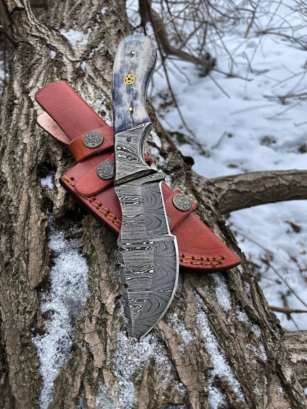 Handmade Damascus steel tracker knife with textured handle and sharp blade, crafted by Knives Gear Garage.