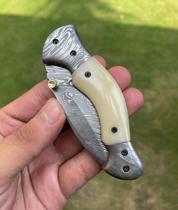 Damascus folding pocket knife by cskforged with a textured blade and ergonomic handle, ideal for everyday carry.