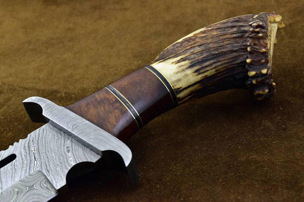 Custom handmade Damascus steel hunting Bowie knife with stag horn handle by Knives Gear Garage, detailed blade and rustic grip.