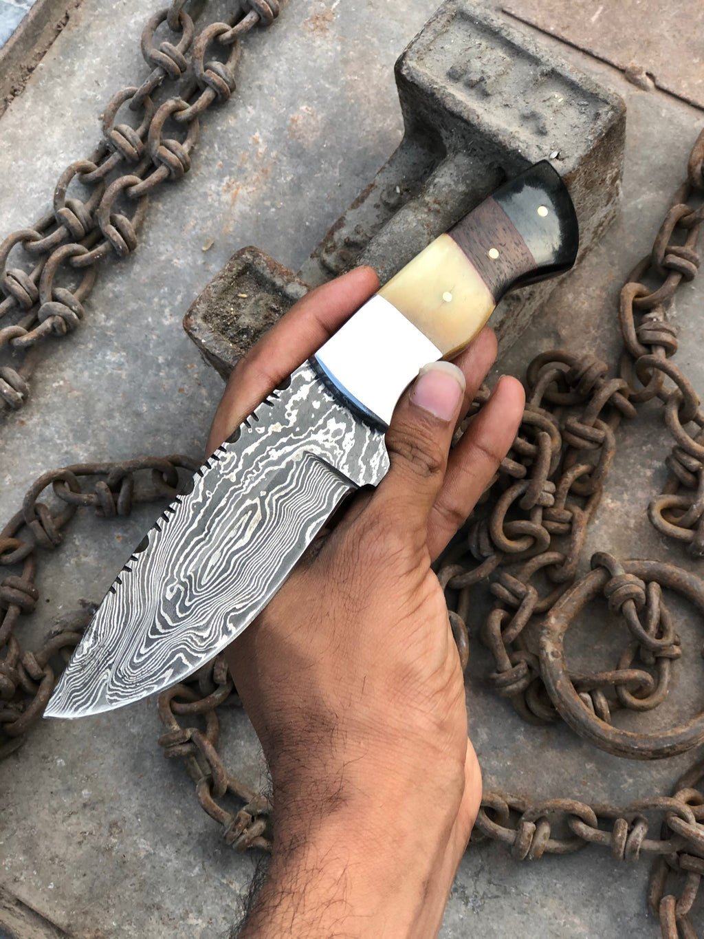 Stainless steel hunting knife from Knives Gear Garage with a textured black handle and a sharp fixed blade for outdoor use.