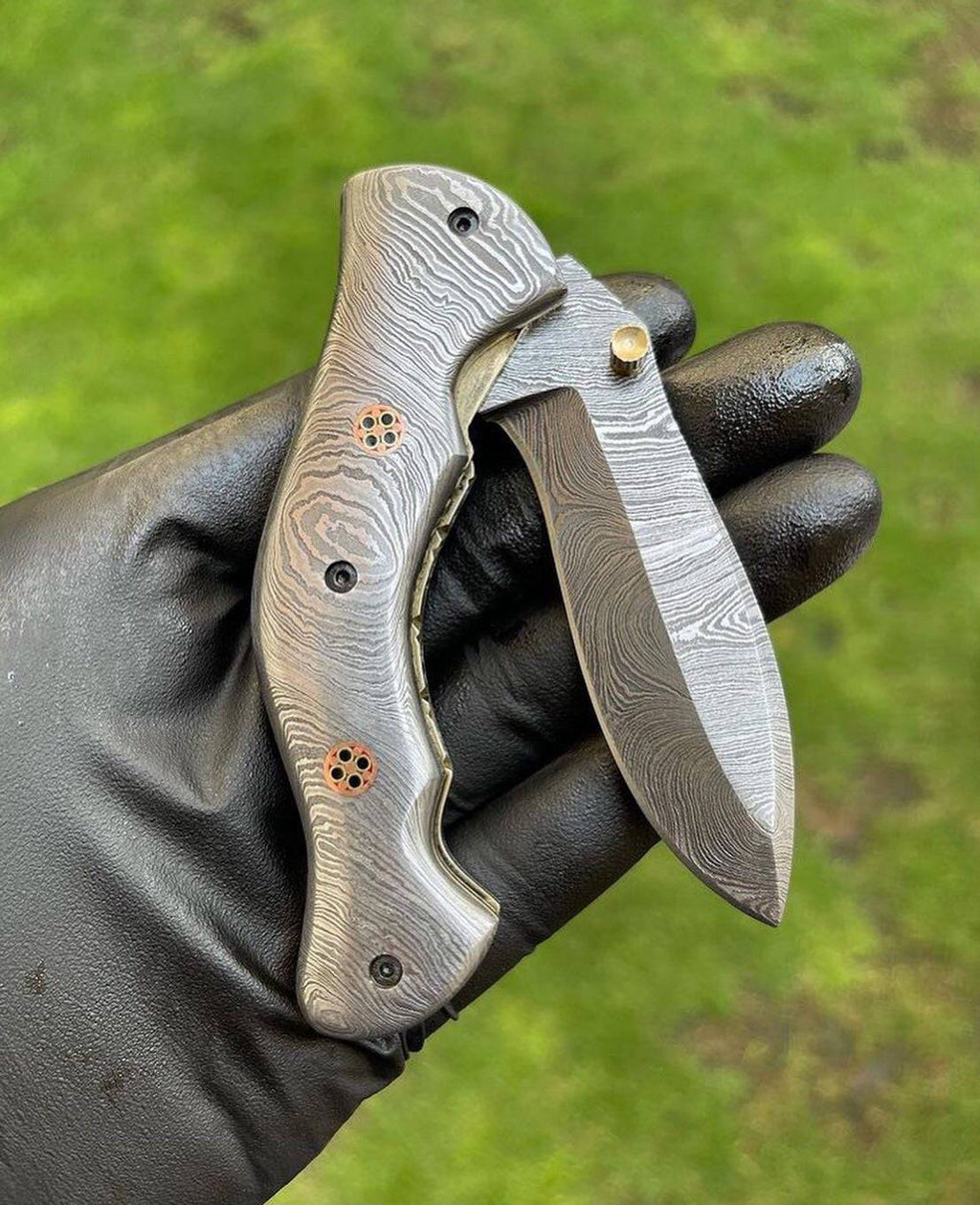 Damascus folding pocket knife with full blade, featuring intricate pattern and ergonomic handle, by cskforged.