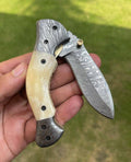 Damascus folding pocket knife by cskforged with a sleek folding blade and textured handle, suitable for everyday carry.