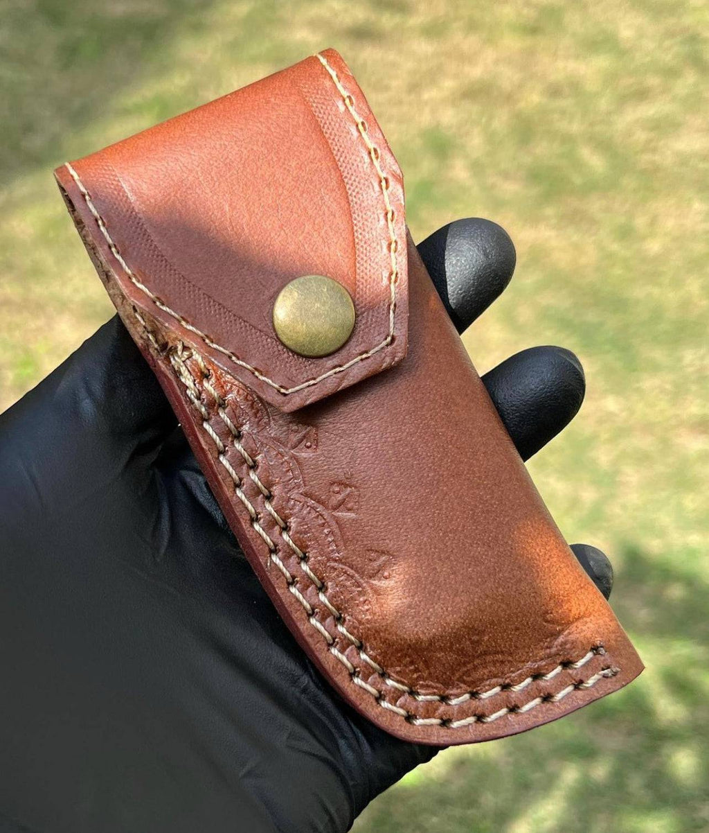 Damascus pocket folding knife by CSK Forged with a detailed patterned blade and a sturdy handle, open for easy use.