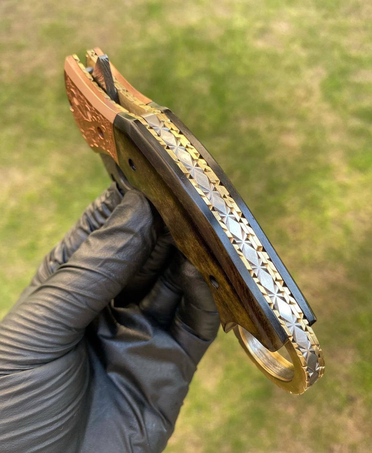 Damascus folding pocket knife with Karambit design from CSK Forged, showcasing intricate blade pattern and ergonomic handle.