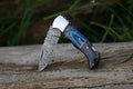 Custom handmade folding knife with 7-inch Damascus steel blade, Pakka wood handle, steel bolster, and leather sheath.