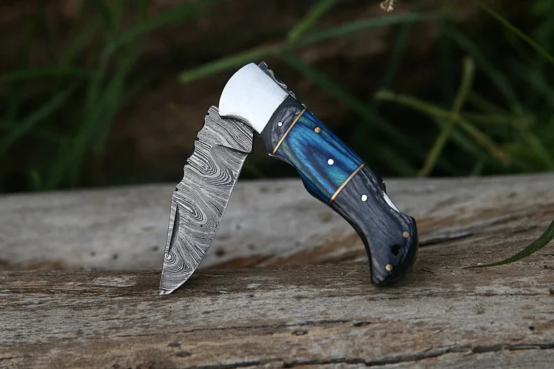 Custom handmade folding knife with 7-inch Damascus steel blade, Pakka wood handle, steel bolster, and leather sheath.