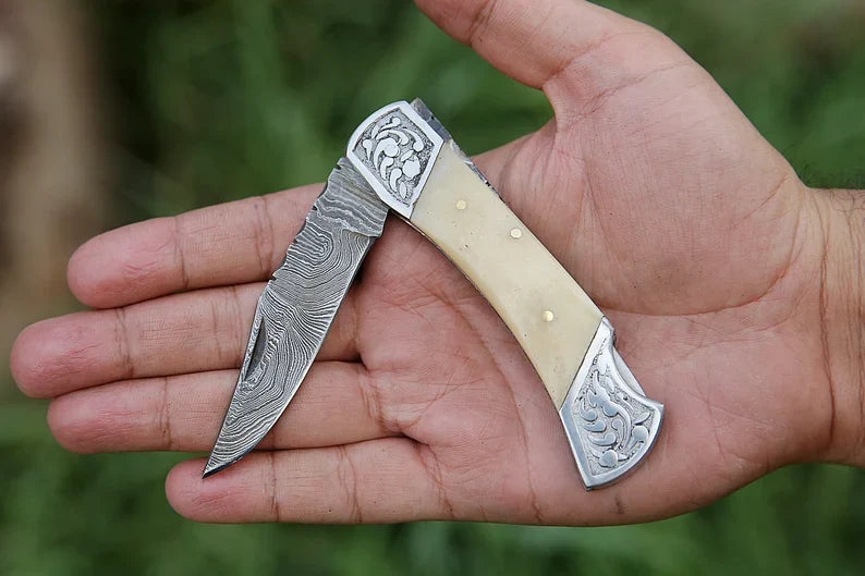 Custom handmade Damascus steel folding pocket knife by Knives Gear Garage with engraved bolster and leather sheath, 7-inch blade.