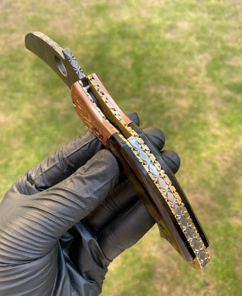 Damascus folding pocket knife with karambit design by cskforged, showcasing a textured Damascus steel blade and ergonomic handle.