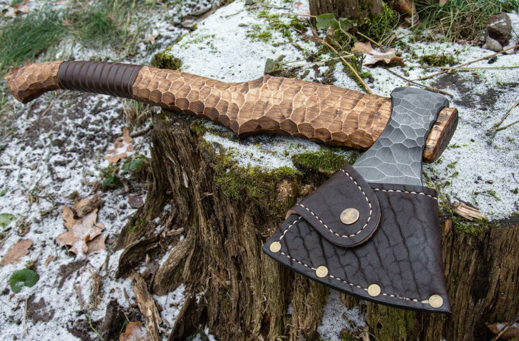 Hand-forged axe from Knives Gear Garage with wooden handle and sharp metal blade, suitable for chopping and outdoor use.
