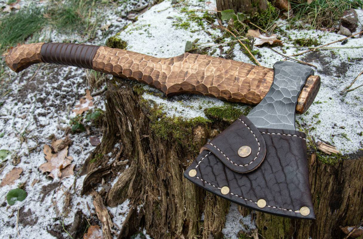 Hand-forged axe from Knives Gear Garage with wooden handle and sharp metal blade, suitable for chopping and outdoor use.