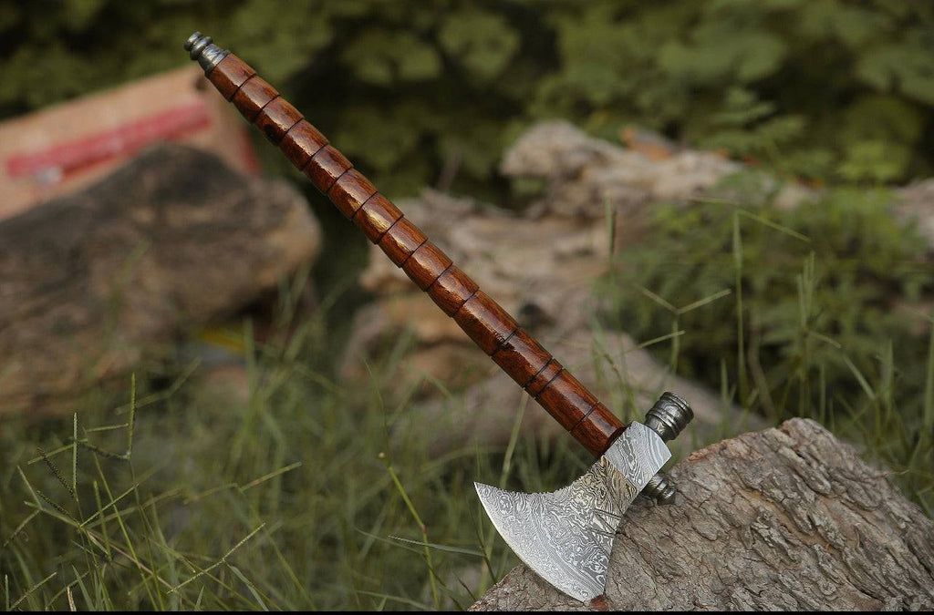 Damascus hunting axe with rosewood handle and leather sheath, featuring intricate blade design from Knives Gear Garage.