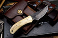 Handmade 7-inch Damascus steel deer skinning knife with camel bone handle and leather sheath, ideal for hunting and skinning tasks.
