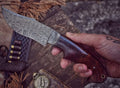 Custom handmade Damascus steel hunting knife with a textured handle and sharp blade, crafted by Knives Gear Garage.